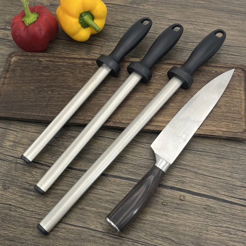 Fusils à aiguiser diamantés posés sur une planche en bois à côté d un couteau de chef